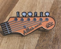 a pin with an orange guitar on it